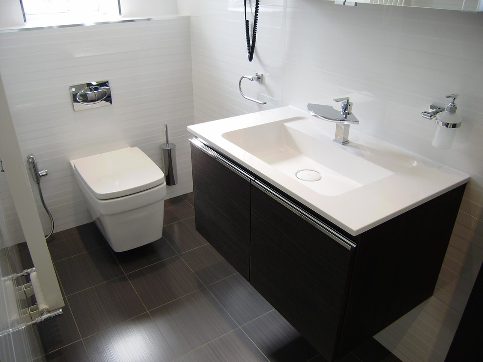 Small contemporary shower room bathroom in West Midlands with a wall-mounted sink, flat-panel cabinets, grey cabinets, solid surface worktops, a claw-foot bath, an alcove shower, a wall mounted toilet, white tiles, porcelain tiles, white walls and porcelain flooring.