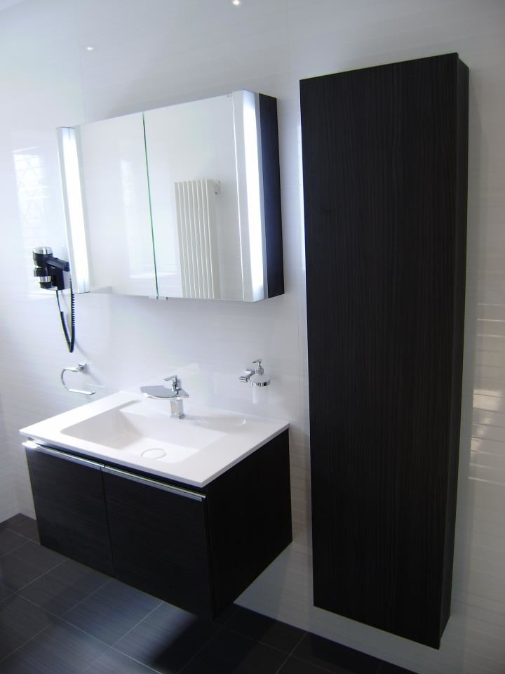 Exempel på ett litet modernt badrum med dusch, med ett väggmonterat handfat, släta luckor, grå skåp, bänkskiva i akrylsten, ett badkar med tassar, en dusch i en alkov, en vägghängd toalettstol, vit kakel, porslinskakel, vita väggar och klinkergolv i porslin