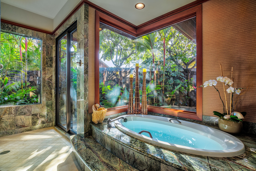 Bild på ett mycket stort tropiskt en-suite badrum, med ett nedsänkt handfat, luckor med upphöjd panel, skåp i mellenmörkt trä, granitbänkskiva, ett platsbyggt badkar, en dusch i en alkov, beige kakel, stenkakel, flerfärgade väggar och travertin golv