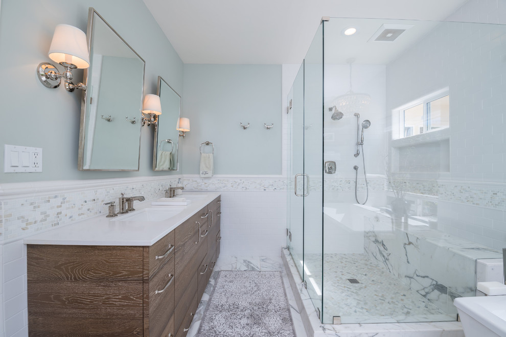 Idées déco pour une salle de bain principale classique en bois foncé de taille moyenne avec un placard à porte plane, une baignoire indépendante, une douche d'angle, WC à poser, un carrelage gris, un carrelage de pierre, un mur bleu, un sol en marbre, un lavabo encastré et un plan de toilette en surface solide.