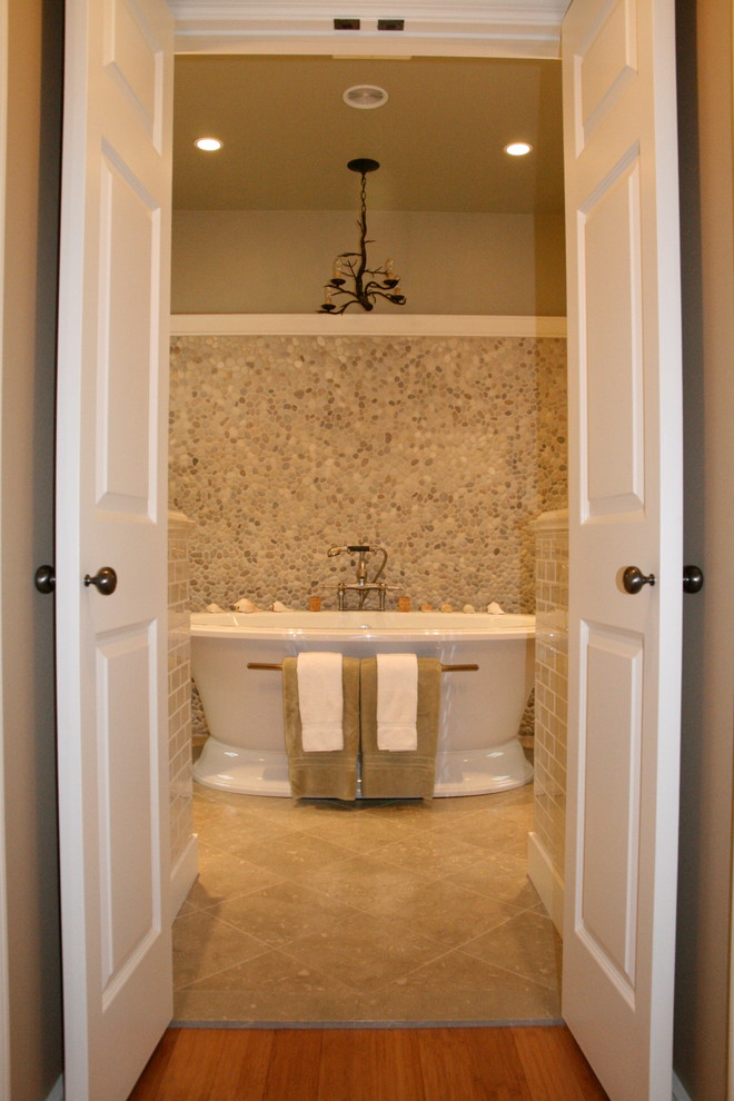 Exemple d'une salle de bain principale chic en bois clair de taille moyenne avec un lavabo encastré, un placard à porte shaker, un plan de toilette en quartz modifié, une baignoire indépendante, un carrelage beige, un carrelage de pierre, un mur vert, un sol en calcaire et WC à poser.