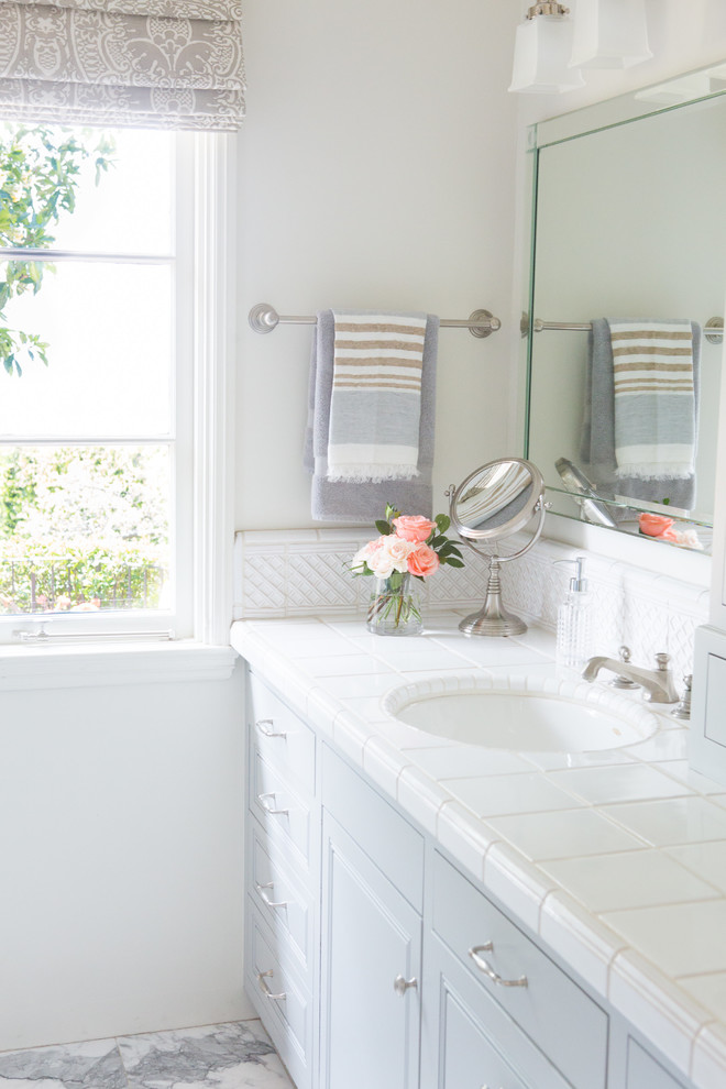 Foto på ett mellanstort vintage vit en-suite badrum, med luckor med infälld panel, grå skåp, en dusch i en alkov, beige väggar, marmorgolv, ett undermonterad handfat, kaklad bänkskiva, vitt golv och dusch med gångjärnsdörr