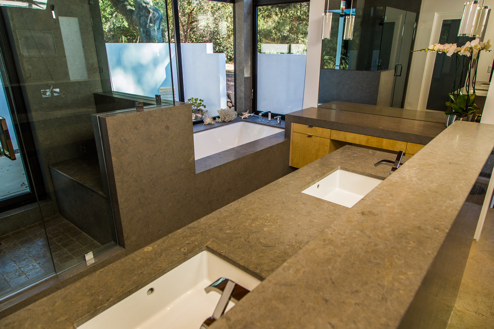 Modern inredning av ett stort en-suite badrum, med öppna hyllor, gula skåp, ett undermonterat badkar, en öppen dusch, grå kakel, kakelplattor, vita väggar, kalkstensgolv, ett undermonterad handfat och bänkskiva i kalksten