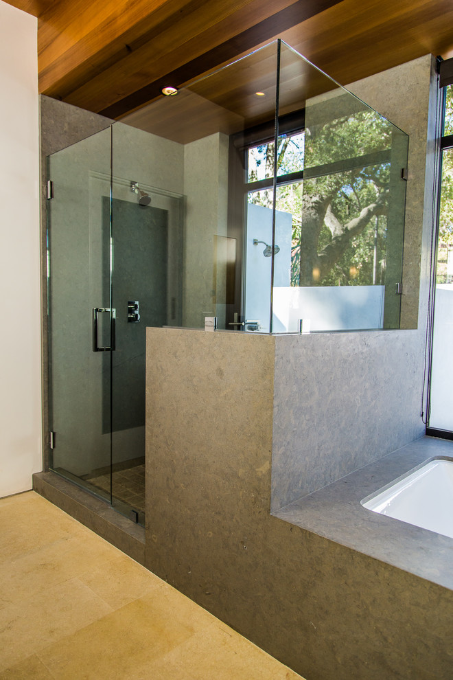 Foto på ett funkis en-suite badrum, med öppna hyllor, gula skåp, ett undermonterat badkar, en öppen dusch, grå kakel, kakelplattor, vita väggar, kalkstensgolv, ett undermonterad handfat och bänkskiva i kalksten
