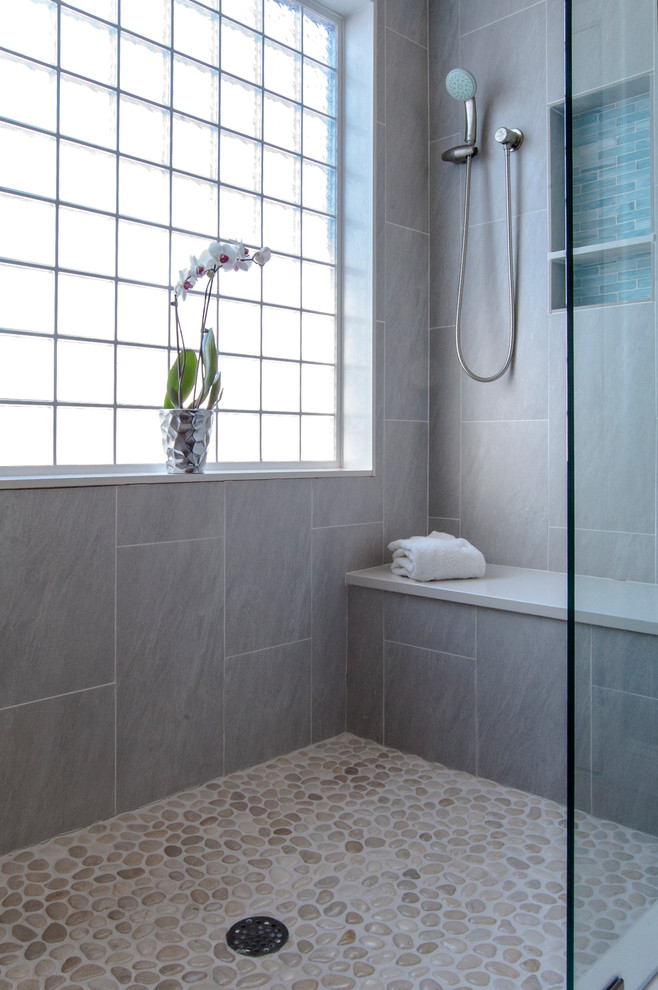 Aménagement d'une grande salle de bain principale moderne avec un carrelage gris, une douche ouverte, des carreaux de porcelaine, un mur gris et un sol en galet.