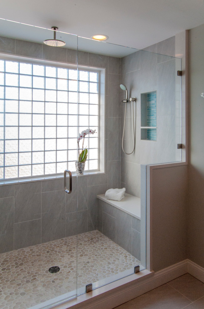 Пример оригинального дизайна: большая главная ванная комната в стиле модернизм с серыми стенами, полом из галечной плитки, врезной раковиной, плоскими фасадами, темными деревянными фасадами, столешницей из искусственного кварца, двойным душем, унитазом-моноблоком, синей плиткой, стеклянной плиткой, серым полом и душем с распашными дверями