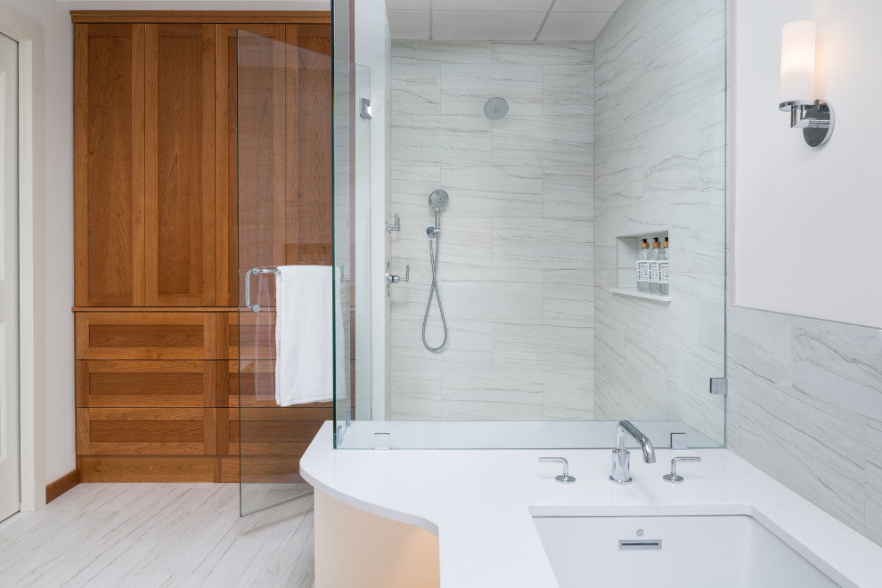 Large ensuite bathroom in Burlington with flat-panel cabinets, medium wood cabinets, a submerged bath, a corner shower, a bidet, porcelain tiles, ceramic flooring, quartz worktops, a hinged door, white worktops, double sinks and a built in vanity unit.
