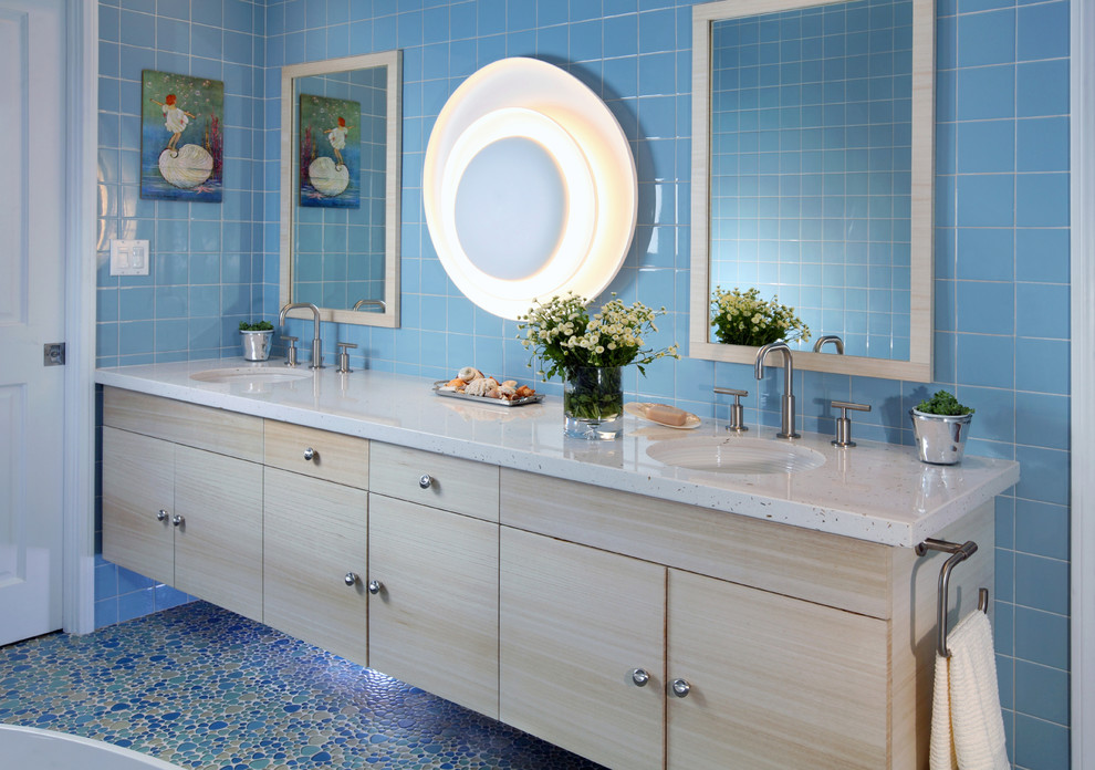 Imagen de cuarto de baño con puerta corredera actual con puertas de armario de madera clara, baldosas y/o azulejos azules, suelo con mosaicos de baldosas y suelo azul