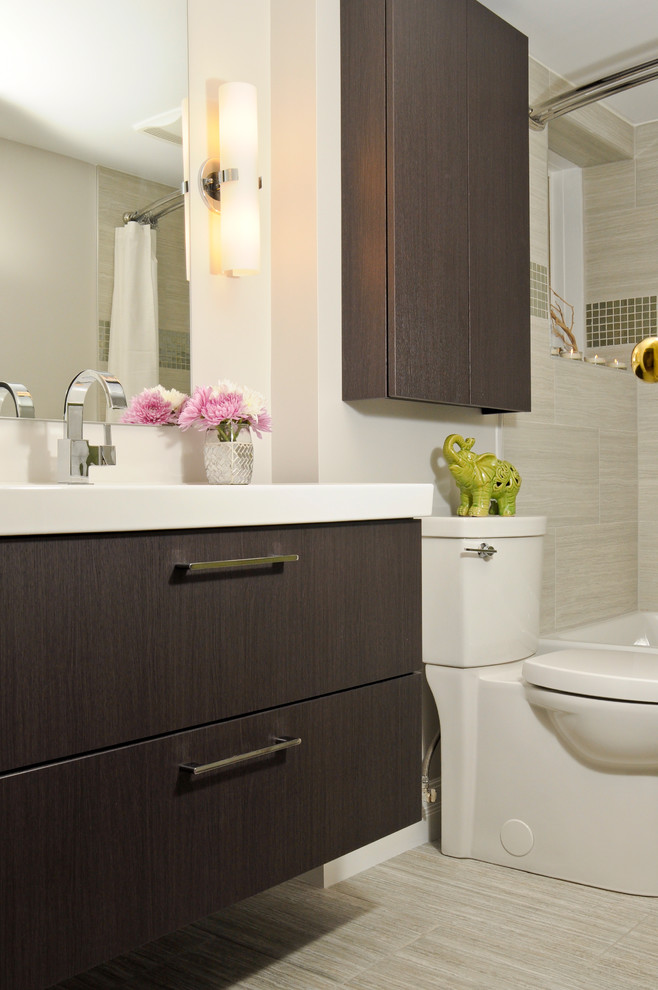 Foto på ett funkis badrum, med släta luckor, skåp i mörkt trä, en dusch/badkar-kombination, en toalettstol med separat cisternkåpa, beige väggar och ett väggmonterat handfat