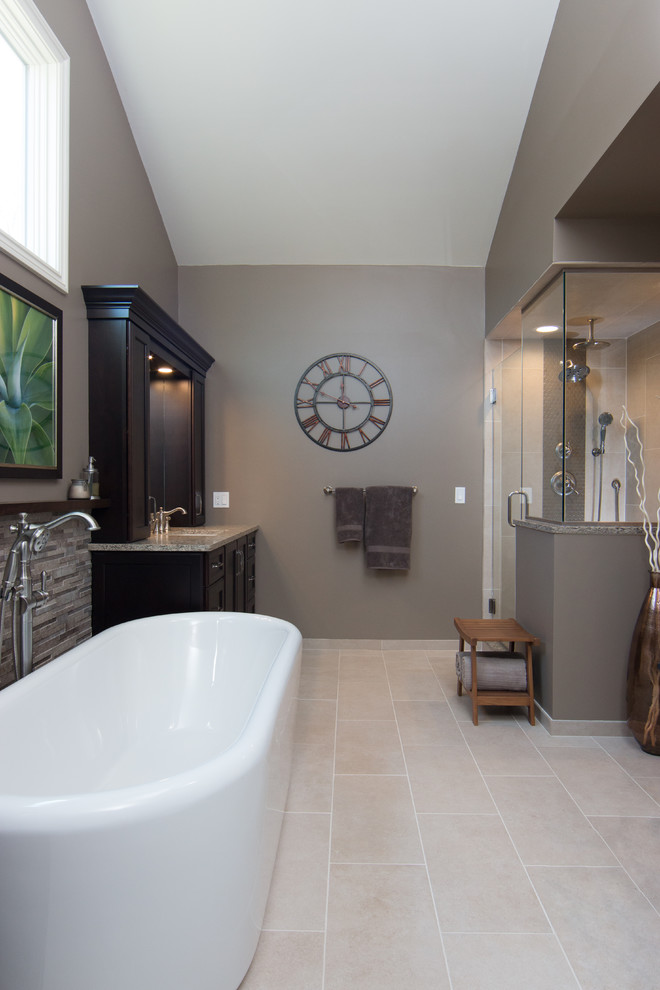 This is an example of a large traditional ensuite bathroom in Detroit with flat-panel cabinets, brown cabinets, a freestanding bath, a walk-in shower, a two-piece toilet, grey tiles, porcelain tiles, brown walls, porcelain flooring, a submerged sink and engineered stone worktops.