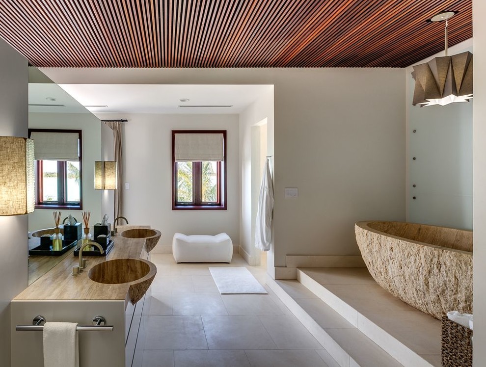 Photo of a contemporary bathroom in Other with flat-panel cabinets, a freestanding bath, white walls and brown worktops.