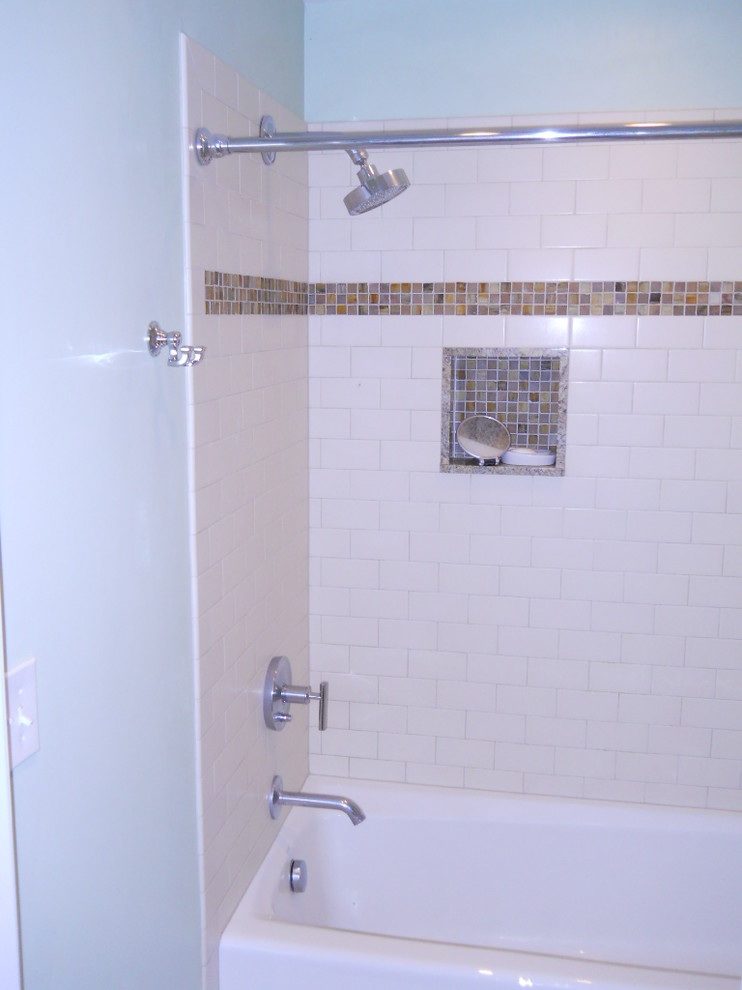 Cette image montre une grande salle de bain principale traditionnelle en bois brun avec une baignoire en alcôve, un combiné douche/baignoire, un carrelage blanc, un mur bleu, un placard à porte shaker, un carrelage métro, un lavabo encastré et un plan de toilette en granite.