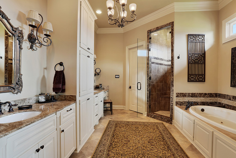 Photo of a medium sized traditional ensuite bathroom in New Orleans with a built-in sink, raised-panel cabinets, white cabinets, marble worktops, a built-in bath, a corner shower, brown tiles, porcelain tiles, beige walls and porcelain flooring.