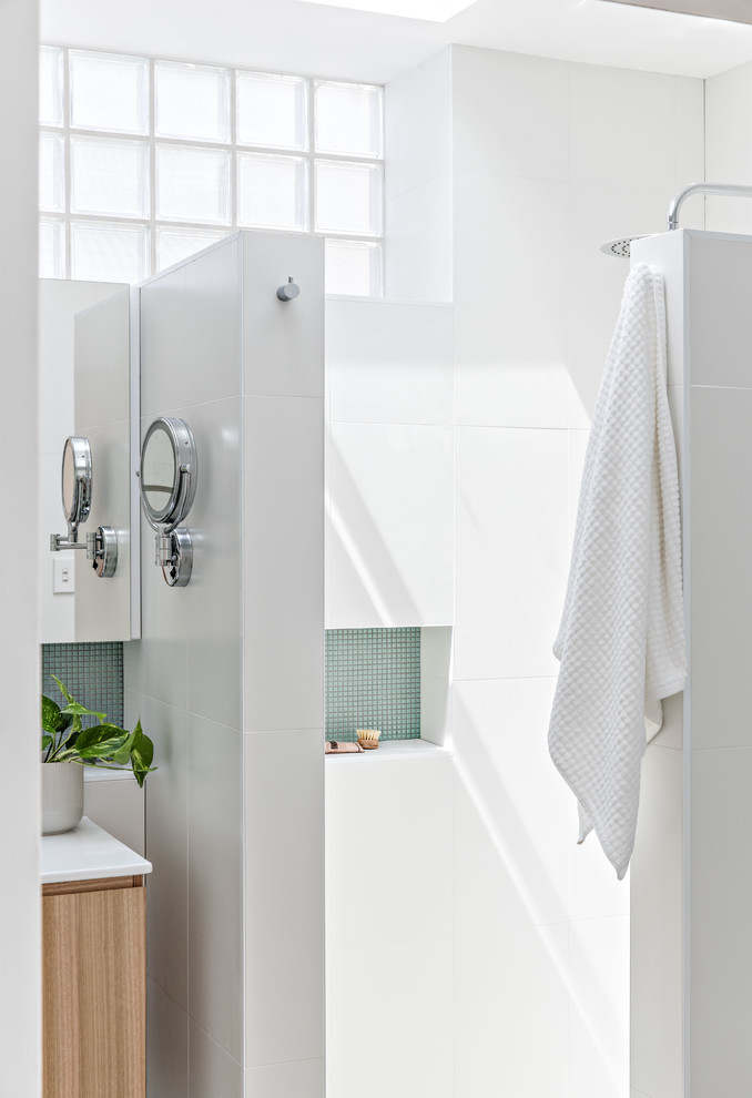 Inspiration for a medium sized contemporary ensuite bathroom in Sydney with medium wood cabinets, a built-in bath, a corner shower, white tiles, ceramic tiles, white walls, porcelain flooring, a wall-mounted sink, grey floors and an open shower.