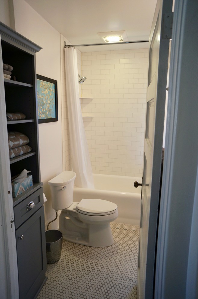 Пример оригинального дизайна: маленькая главная ванная комната в классическом стиле с фасадами в стиле шейкер, серыми фасадами, раздельным унитазом, белой плиткой, плиткой кабанчик, белыми стенами, полом из мозаичной плитки, врезной раковиной, столешницей из искусственного кварца, шторкой для ванной, ванной в нише, душем над ванной, белым полом, белой столешницей, тумбой под одну раковину и напольной тумбой для на участке и в саду