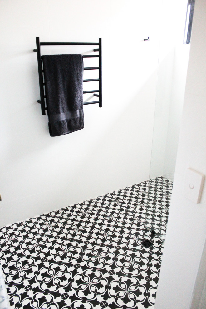 Inredning av ett mellanstort vit vitt badrum för barn, med släta luckor, skåp i mörkt trä, en öppen dusch, vit kakel, keramikplattor, vita väggar, mosaikgolv, ett fristående handfat, svart golv och med dusch som är öppen