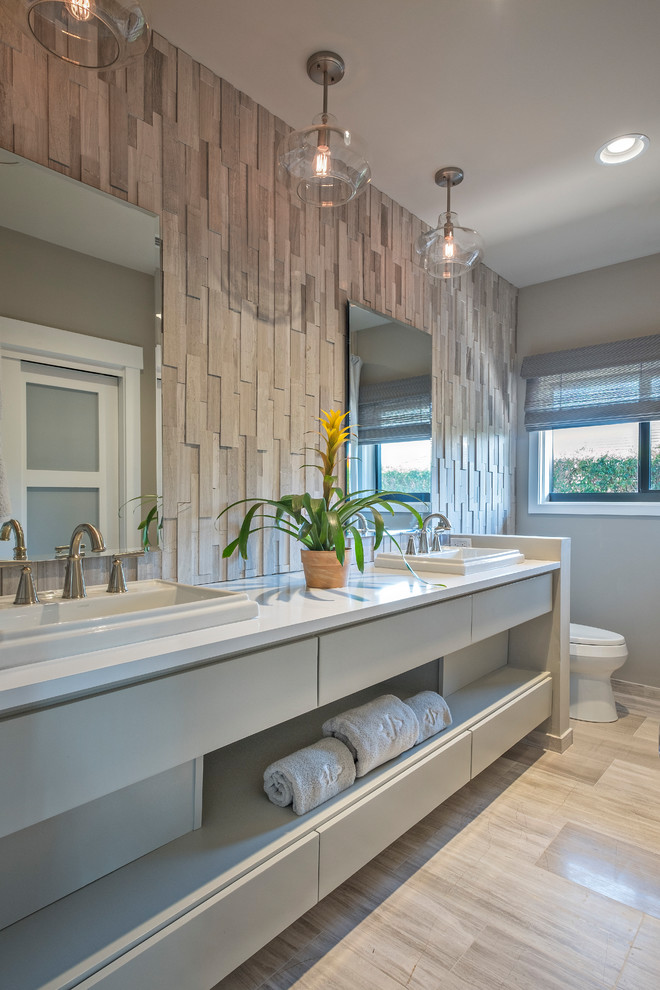 Mittelgroßes Klassisches Badezimmer En Suite mit flächenbündigen Schrankfronten, weißen Schränken, Toilette mit Aufsatzspülkasten, beiger Wandfarbe, Porzellan-Bodenfliesen, Einbauwaschbecken und Mineralwerkstoff-Waschtisch in Miami