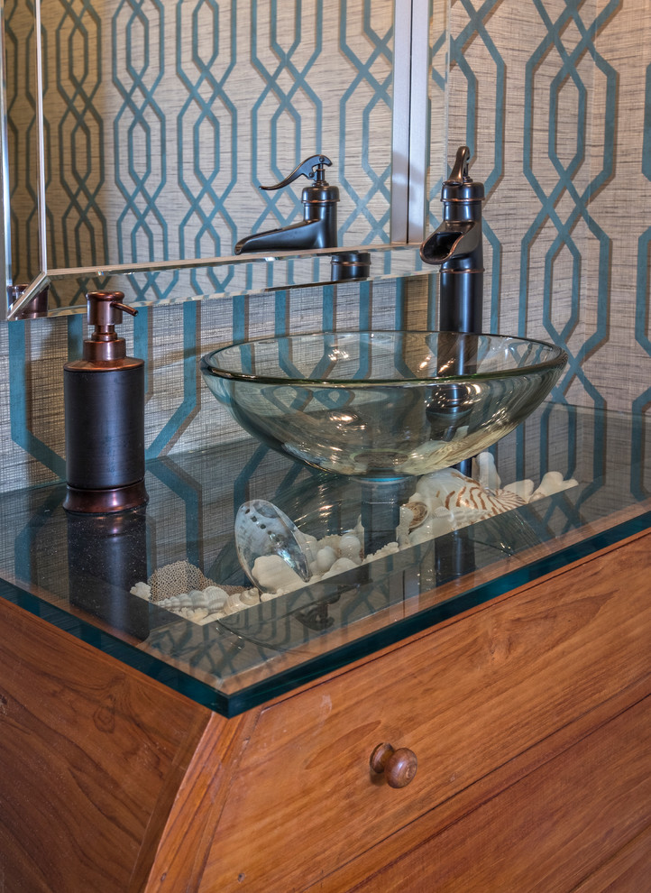 Exemple d'une petite salle d'eau bord de mer en bois brun avec un placard en trompe-l'oeil, parquet foncé, une vasque et un plan de toilette en verre.