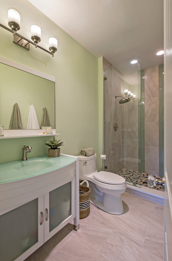Modelo de cuarto de baño clásico renovado de tamaño medio con armarios tipo vitrina, puertas de armario blancas, ducha empotrada, sanitario de una pieza, baldosas y/o azulejos de porcelana, paredes verdes, suelo de baldosas de porcelana, lavabo integrado y encimera de vidrio
