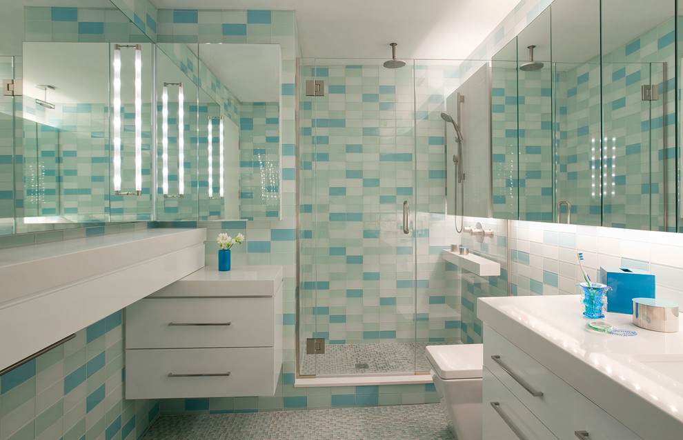 Стильный дизайн: главная ванная комната среднего размера в стиле модернизм с плоскими фасадами, белыми фасадами, гидромассажной ванной, душем в нише, синей плиткой, стеклянной плиткой, столешницей из искусственного кварца и душем с распашными дверями - последний тренд