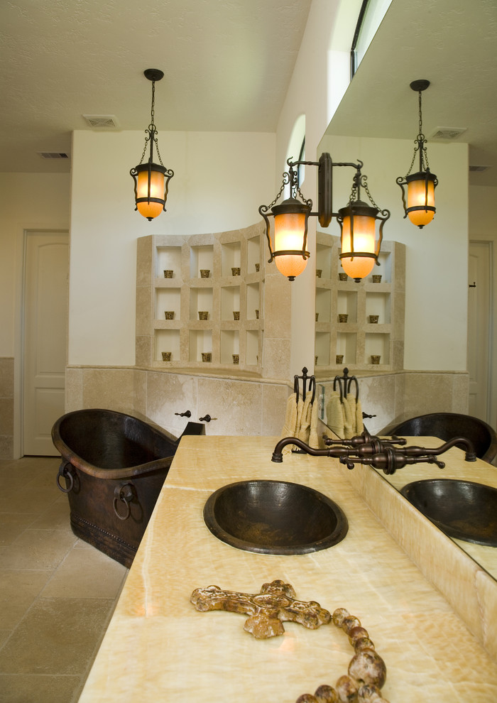 Immagine di una stanza da bagno mediterranea con vasca freestanding e top in superficie solida
