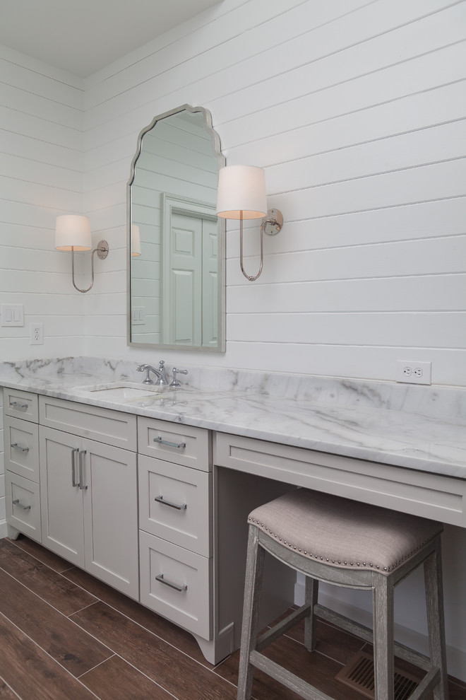 Свежая идея для дизайна: главная ванная комната среднего размера в стиле кантри с фасадами в стиле шейкер, серыми фасадами, полновстраиваемой ванной, открытым душем, раздельным унитазом, белой плиткой, керамической плиткой, белыми стенами, полом из керамогранита, врезной раковиной, мраморной столешницей, коричневым полом, душем с распашными дверями и белой столешницей - отличное фото интерьера