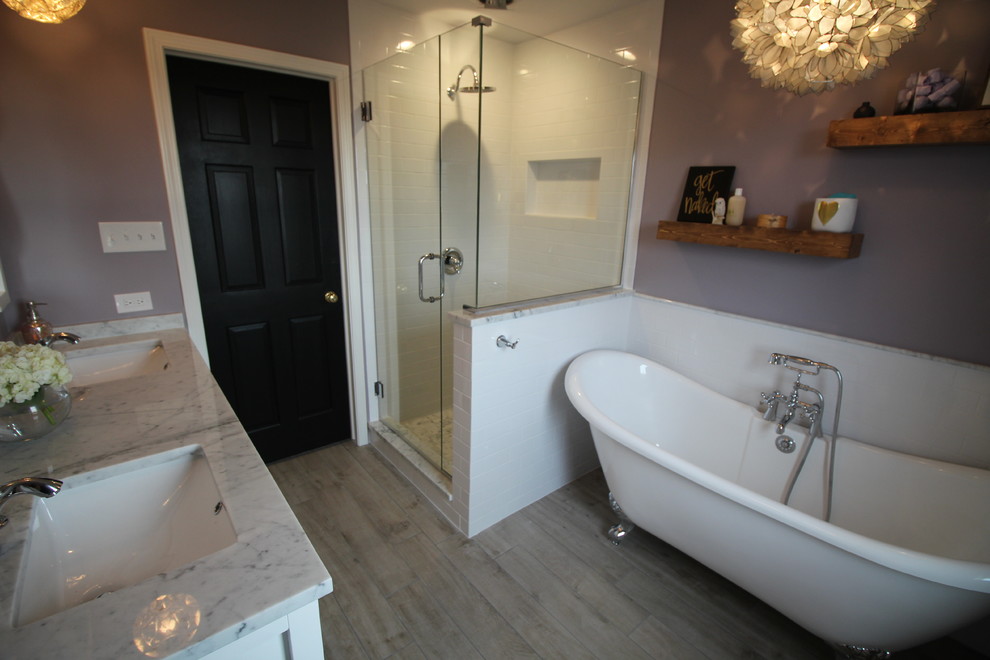 Exemple d'une douche en alcôve principale romantique de taille moyenne avec un placard à porte shaker, des portes de placard blanches, une baignoire sur pieds, WC à poser, un carrelage blanc, un carrelage métro, un mur violet, un sol en carrelage de porcelaine, un lavabo encastré et un plan de toilette en marbre.