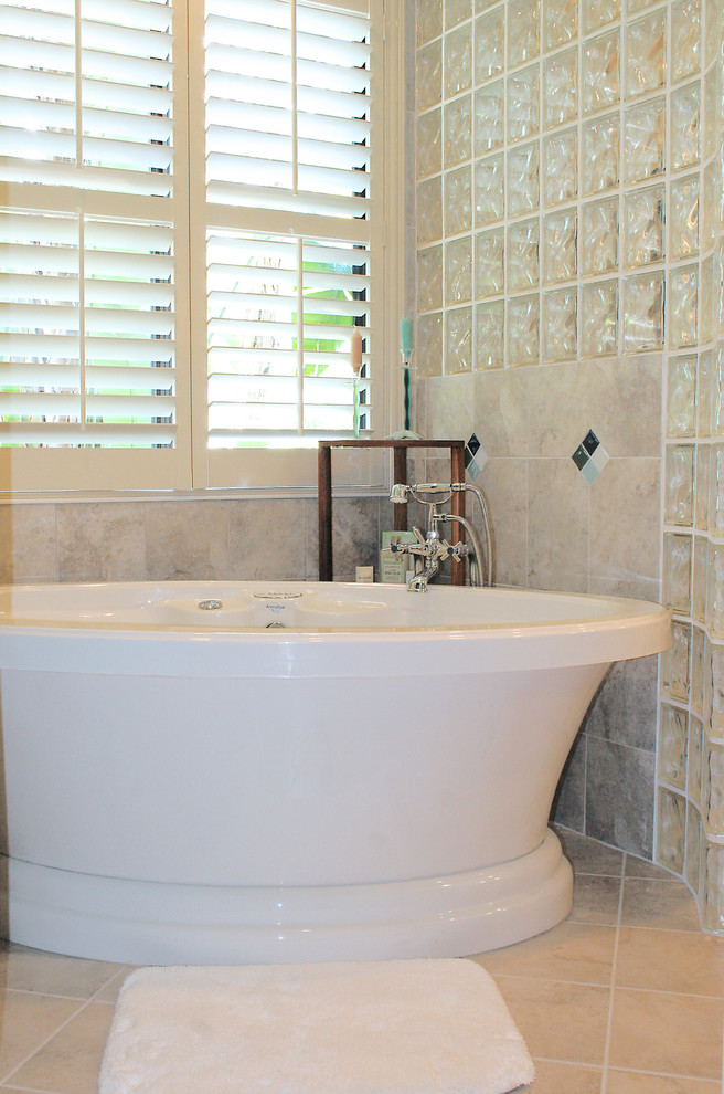 Cette photo montre une salle de bain principale romantique en bois brun avec une baignoire indépendante, un carrelage beige, un mur bleu, une vasque et une douche ouverte.