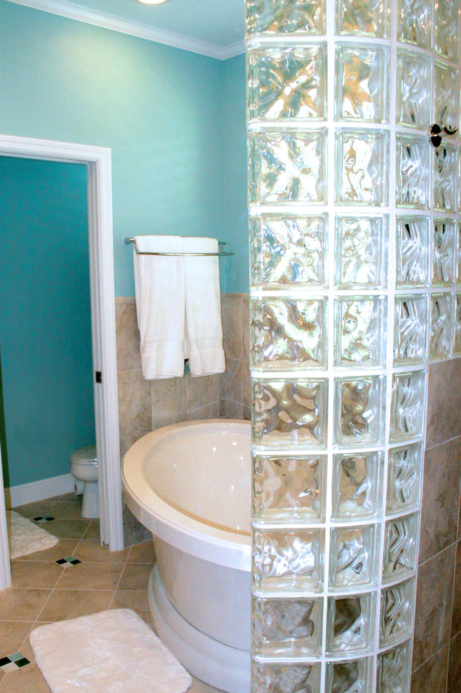 Eklektisches Badezimmer En Suite mit freistehender Badewanne, beigen Fliesen, blauer Wandfarbe, Aufsatzwaschbecken, hellbraunen Holzschränken, offener Dusche und flächenbündigen Schrankfronten in Tampa