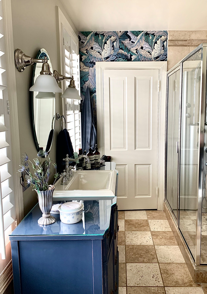 На фото: маленькая ванная комната в стиле шебби-шик с фасадами островного типа, искусственно-состаренными фасадами, двойным душем, бежевой плиткой, плиткой из травертина, разноцветными стенами, полом из травертина, душевой кабиной, накладной раковиной, стеклянной столешницей, бежевым полом, душем с раздвижными дверями, синей столешницей, тумбой под одну раковину, напольной тумбой и обоями на стенах для на участке и в саду