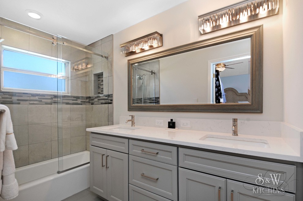 This is an example of a small contemporary ensuite bathroom in Tampa with recessed-panel cabinets, grey cabinets, an alcove bath, a two-piece toilet, grey tiles, porcelain tiles, white walls, porcelain flooring, a submerged sink and engineered stone worktops.