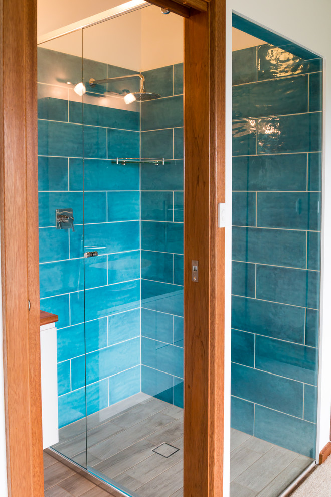 Idee per una piccola stanza da bagno con doccia minimal con consolle stile comò, ante bianche, doccia ad angolo, WC monopezzo, piastrelle in ceramica, pareti blu, pavimento in gres porcellanato, top in legno e piastrelle blu