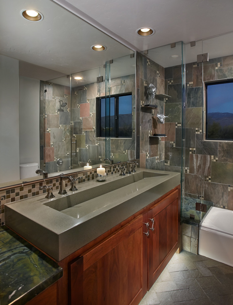 Idéer för ett litet klassiskt badrum, med ett avlångt handfat, bänkskiva i betong, ett badkar i en alkov, en dusch/badkar-kombination, en toalettstol med separat cisternkåpa, mosaik, grå väggar och tegelgolv