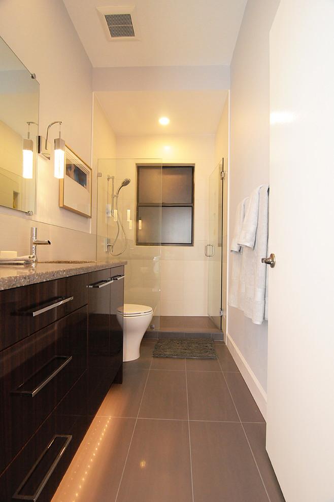 Idéer för att renovera ett mellanstort funkis badrum med dusch, med ett undermonterad handfat, släta luckor, bruna skåp, bänkskiva i kvarts, en dusch i en alkov, en toalettstol med separat cisternkåpa, grå kakel, porslinskakel, grå väggar och klinkergolv i porslin