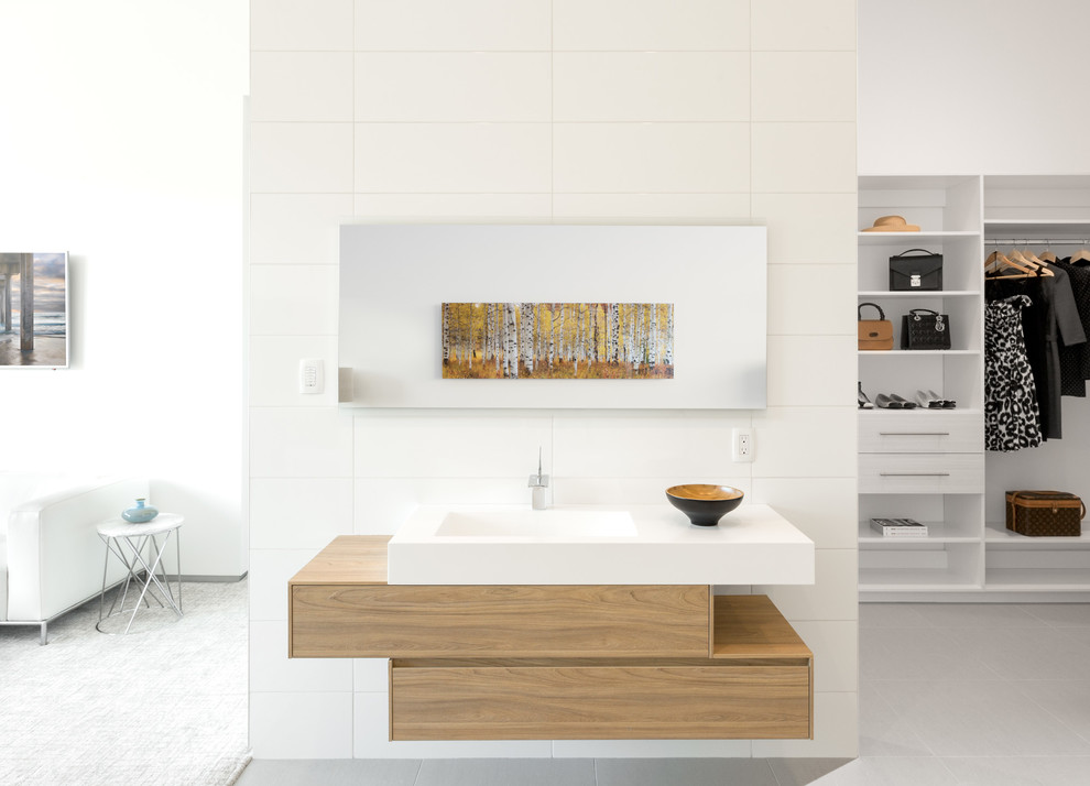 Inspiration for a large modern master white tile and porcelain tile porcelain tile bathroom remodel in Las Vegas with furniture-like cabinets, light wood cabinets, a one-piece toilet, white walls, an integrated sink and quartz countertops