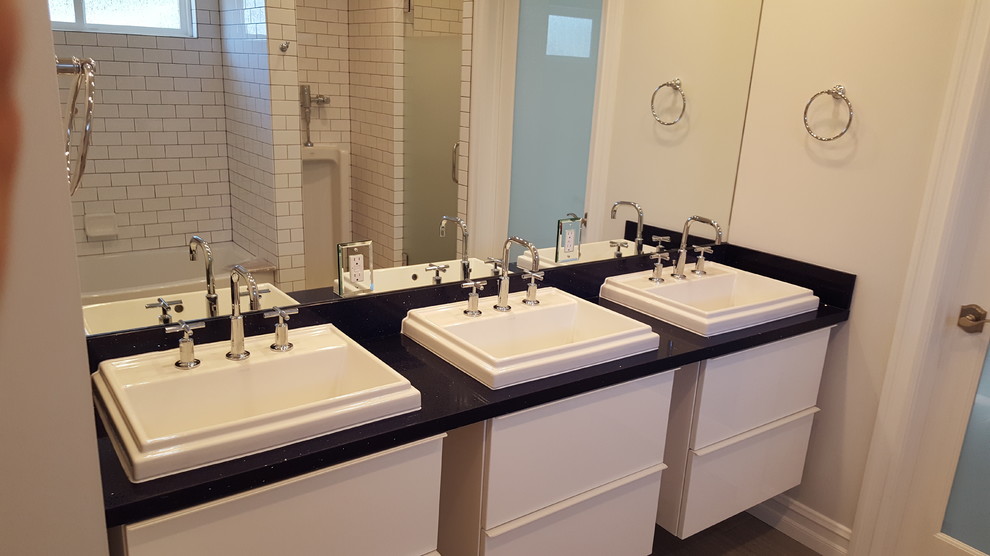 Imagen de cuarto de baño principal actual con armarios con paneles lisos, puertas de armario blancas, baldosas y/o azulejos blancos, baldosas y/o azulejos de cemento, paredes grises y lavabo encastrado