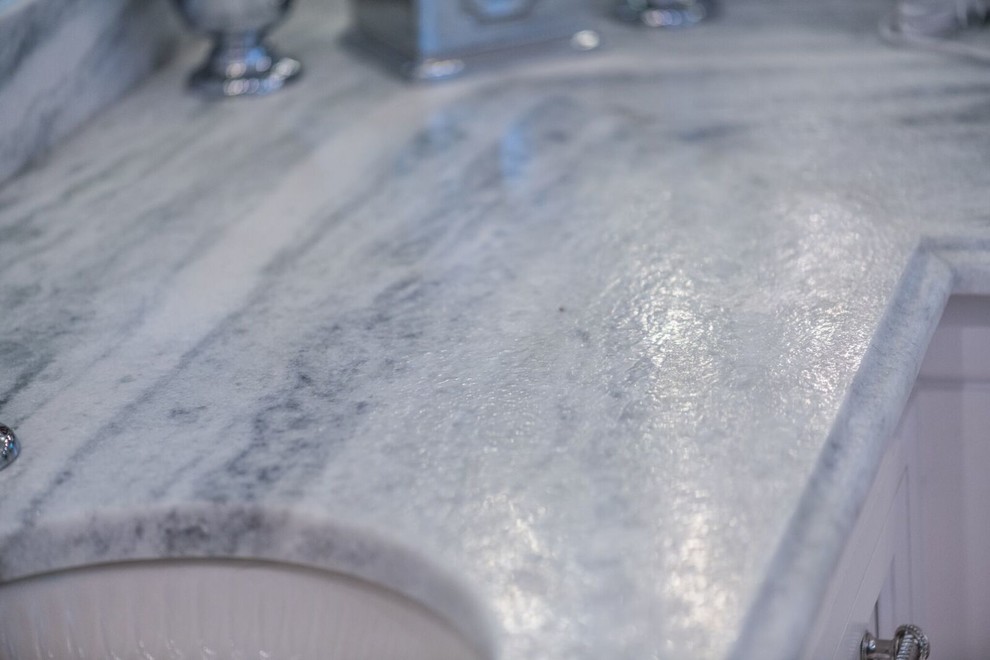 Immagine di una grande stanza da bagno con piastrelle a specchio, lavabo sottopiano e top in marmo
