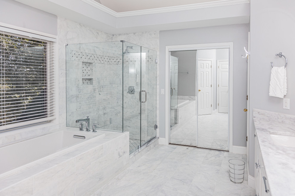 Inspiration for a large contemporary ensuite bathroom in Atlanta with shaker cabinets, white cabinets, a built-in bath, a walk-in shower, a two-piece toilet, white tiles, marble tiles, grey walls, marble flooring, a submerged sink, quartz worktops, white floors, a hinged door, white worktops, a wall niche, double sinks, a built in vanity unit and a vaulted ceiling.