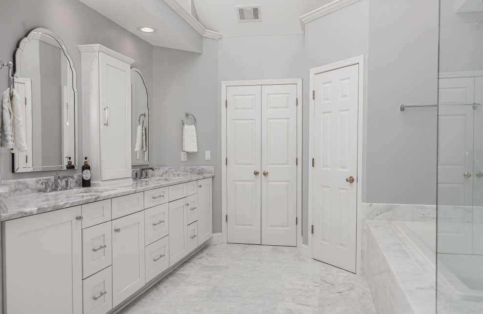 Inspiration pour une grande salle de bain principale design avec un placard à porte shaker, des portes de placard blanches, une baignoire posée, une douche ouverte, WC séparés, un carrelage blanc, du carrelage en marbre, un mur gris, un sol en marbre, un lavabo encastré, un plan de toilette en quartz, un sol blanc, une cabine de douche à porte battante, un plan de toilette blanc, une niche, meuble double vasque, meuble-lavabo encastré et un plafond voûté.