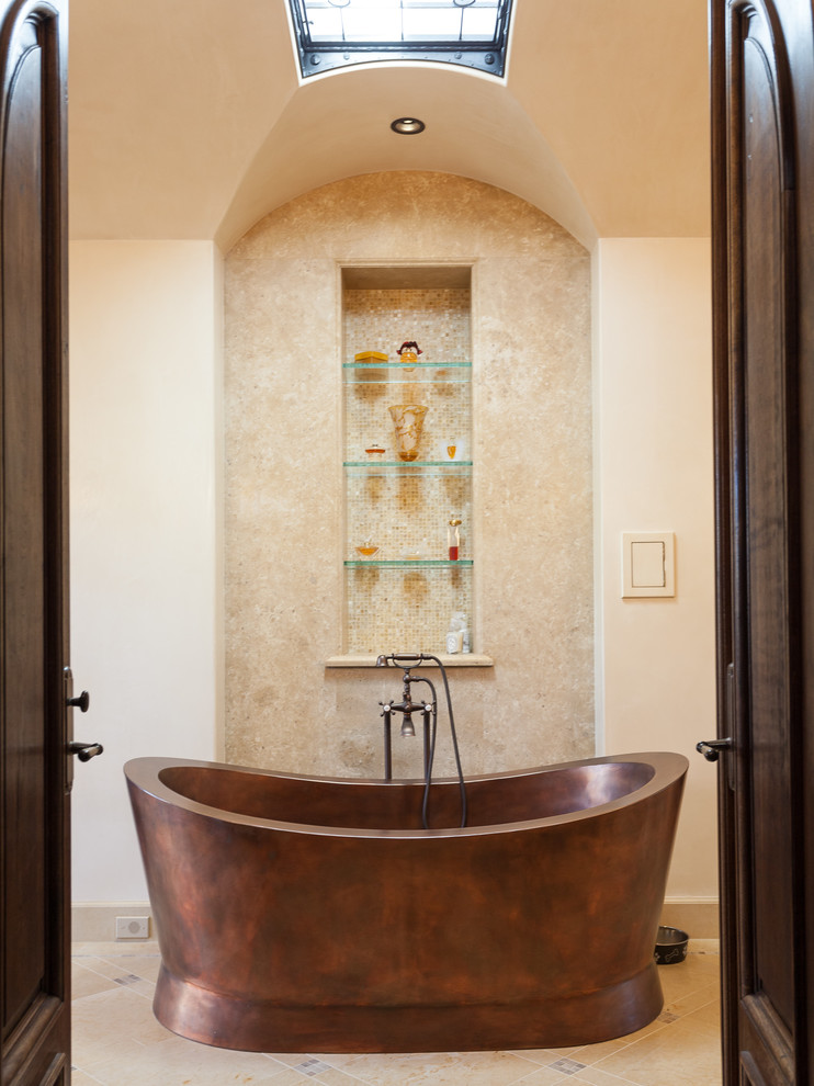 オレンジカウンティにある地中海スタイルのおしゃれな浴室 (置き型浴槽、ベージュのタイル、ベージュの壁) の写真