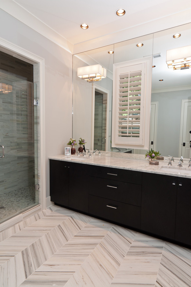 Immagine di una stanza da bagno tradizionale con lavabo sottopiano, ante lisce, ante nere, doccia alcova e piastrelle grigie