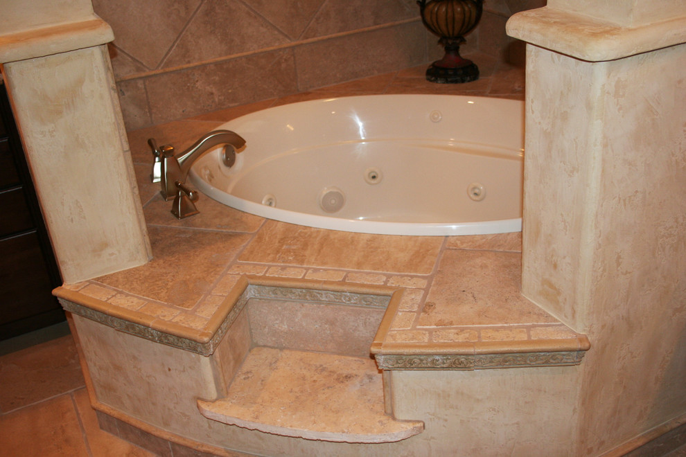 Inspiration for a medium sized mediterranean ensuite bathroom in Austin with a built-in sink, raised-panel cabinets, medium wood cabinets, a built-in bath, a two-piece toilet, beige tiles, stone tiles, beige walls and travertine flooring.