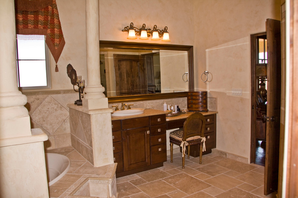 Idéer för små medelhavsstil en-suite badrum, med ett nedsänkt handfat, luckor med upphöjd panel, skåp i mellenmörkt trä, ett platsbyggt badkar, en toalettstol med separat cisternkåpa, beige kakel, stenkakel, beige väggar och travertin golv