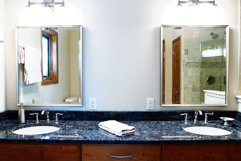 This is an example of a classic bathroom in Milwaukee with a submerged sink, raised-panel cabinets, medium wood cabinets, granite worktops, a double shower, a one-piece toilet, beige tiles, stone tiles, beige walls and porcelain flooring.