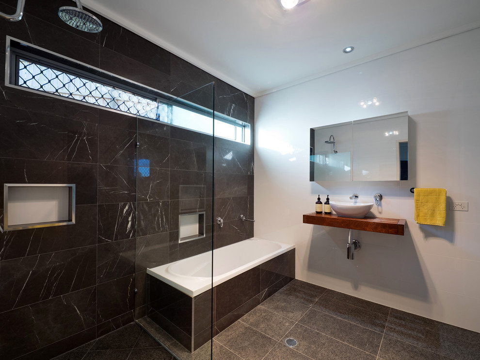 На фото: ванная комната в современном стиле с накладной ванной, открытым душем, настольной раковиной, столешницей из дерева и открытым душем с