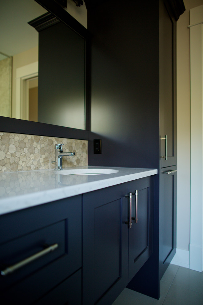 Photo of a large traditional ensuite bathroom in Vancouver with shaker cabinets, black cabinets, a freestanding bath, a walk-in shower, beige tiles, pebble tiles, beige walls, marble flooring, a submerged sink and quartz worktops.