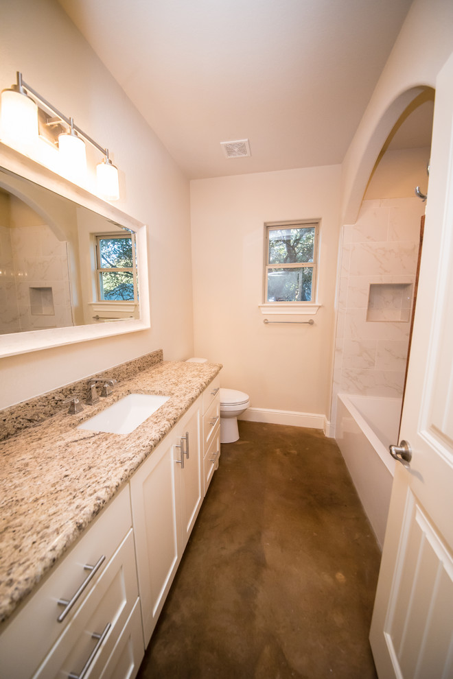 Example of a mid-sized arts and crafts kids' white tile and stone tile concrete floor bathroom design in Austin with white cabinets, an undermount sink, granite countertops, shaker cabinets, a two-piece toilet and beige walls