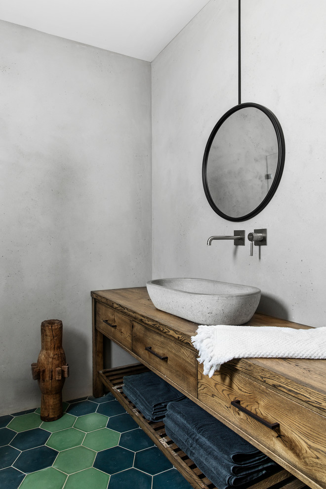 Imagen de cuarto de baño ecléctico con paredes grises, suelo de baldosas de terracota, lavabo sobreencimera, encimera de madera, suelo verde y armarios con paneles lisos