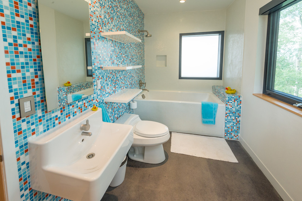 Источник вдохновения для домашнего уюта: детская ванная комната среднего размера в современном стиле с подвесной раковиной, открытыми фасадами, белыми фасадами, ванной в нише, душем над ванной, унитазом-моноблоком, синей плиткой, разноцветной плиткой, плиткой мозаикой, белыми стенами, бетонным полом, серым полом и окном