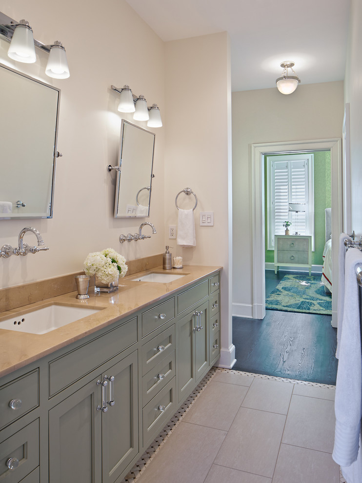 Cette image montre une salle de bain principale traditionnelle de taille moyenne avec un placard à porte affleurante, des portes de placard grises, des carreaux de porcelaine et un lavabo encastré.